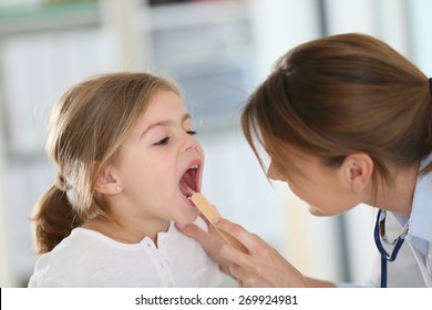 Doctor Examining Child's Throat And Mouth