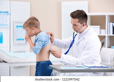 Doctor examining coughing little boy at clinic - Powered by Shutterstock