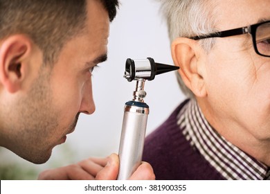 Doctor Examining Ear of a old patient, close up - Powered by Shutterstock