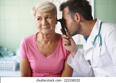 Doctor Examining Ear Of Senior Woman 