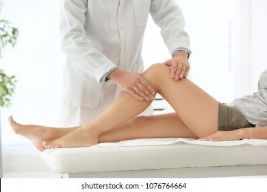 Doctor Examining Female Patient With Injured Leg, Closeup