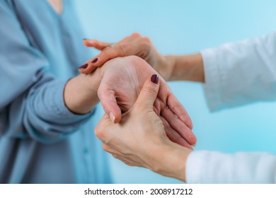 Doctor Examining Hand Of Senior Patient With Pain In Wrist. Carpal Tunnel Syndrome.