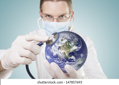 Doctor Examining Health Of Our Planet. Symbol Of Care For Environment Or Global Economy. Elements Of This Image Furnished By NASA.