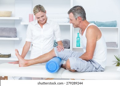 Doctor examining her patient leg in medical office