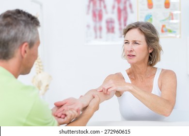 Doctor examining his patients arm in medical office