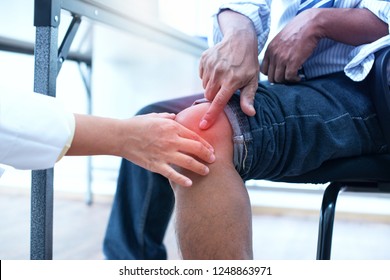 Doctor examining knee bones injury in medical office
