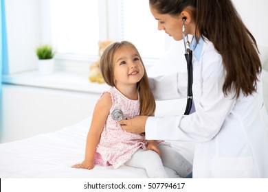 Doctor examining a little girl by stethoscope. Medicine and health care concept.