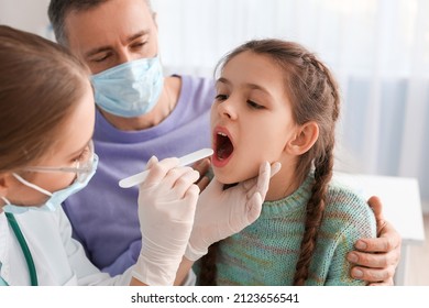 Doctor examining little girl with sore throat in clinic - Powered by Shutterstock