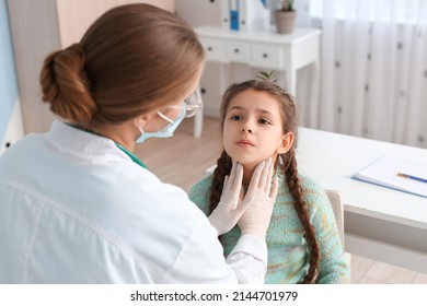 Doctor examining little girl's neck in clinic - Shutterstock ID 2144701979