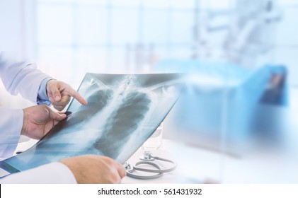 Doctor examining at lungs radiograph x-ray film of patient in operation room. medical concept.