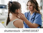 Doctor examining lymp nodes on neck of the young girl. Palpation of lymph nodes. Concept of school entry medical exam.