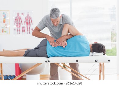 Doctor examining man back in medical office - Powered by Shutterstock