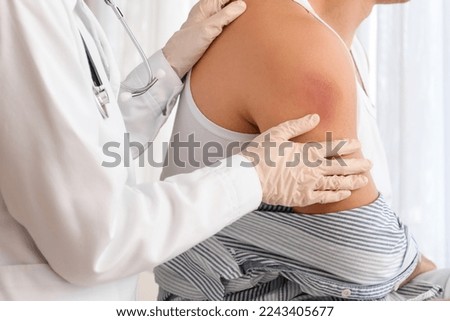 Doctor examining man with bruises in clinic