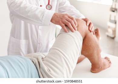 Doctor Examining Mature Man With Joint Pain In Clinic