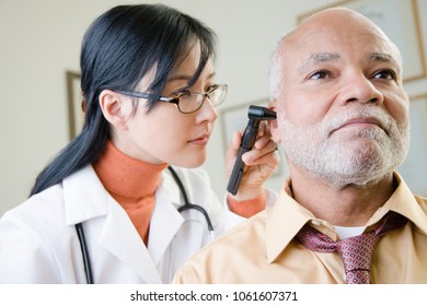 A doctor examining a patients ear - Powered by Shutterstock