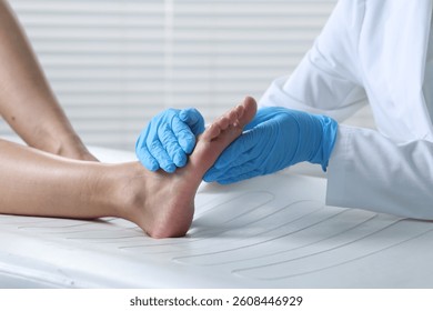 Doctor examining patient's foot in hospital, closeup