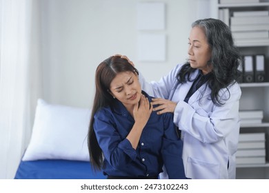 Doctor examining a patient's neck pain in a medical office. The patient appears to be in discomfort while receiving professional care. - Powered by Shutterstock