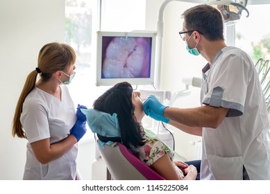 Doctor Examining Patient's Teeth With Intraoral Camera