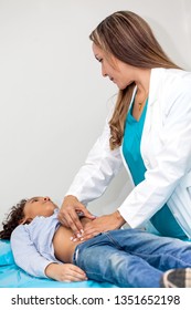 Doctor Examining And Performing The Technique Of Abdominal Percussion To A Child