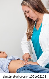 Doctor Examining And Performing The Technique Of Abdominal Percussion To A Child