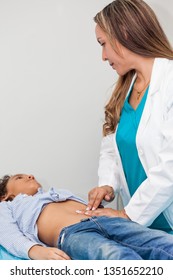 Doctor Examining And Performing The Technique Of Abdominal Percussion To A Child