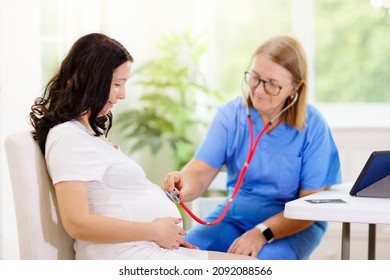 Doctor Examining Pregnant Woman. Pregnancy Check. Young Asian Female At Gynecologist Office For Prenatal Exam. Ob Gyn Showing Patient Baby Sonogram. Obstetrics And Gynecology Office.