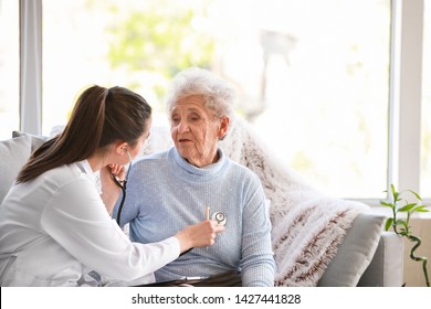 Doctor Examining Senior Woman In Nursing Home