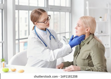 Doctor examining senior woman with thyroid gland problem in clinic - Powered by Shutterstock