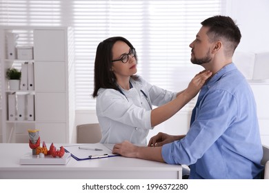 Doctor examining thyroid gland of patient in hospital - Shutterstock ID 1996372280