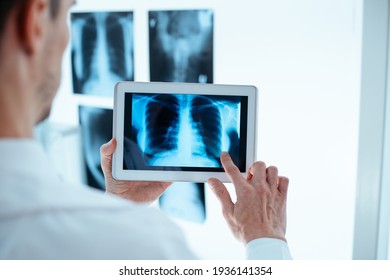 Doctor examining x-ray of chest and ribs on digital tablet. - Powered by Shutterstock