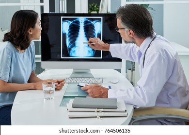 Doctor Explaining Lungs X-ray On Computer Screen To Young Patient