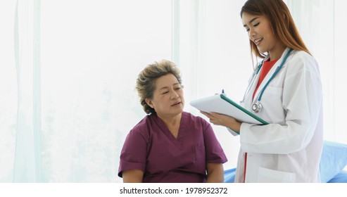 Doctor Explaining Medication To Old Woman Patient At Hospitals