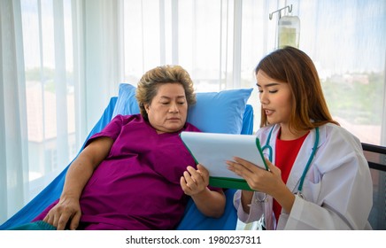 Doctor Explaining Medication To Old Woman Patient At Hospitals