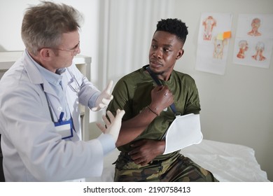 Doctor Explaining Military Man With Broken Arm How To Adapt To Live With Sling