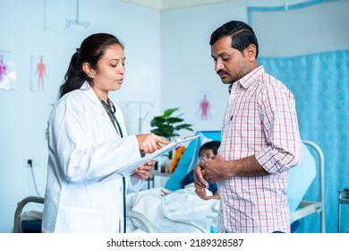 Doctor explaining patient health or medical report to worried father at hospital - concept of professional occupation, advising and treatment. - Powered by Shutterstock