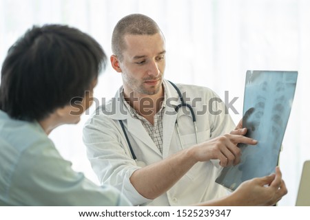 Doctor explaining result of radiography test to patient.