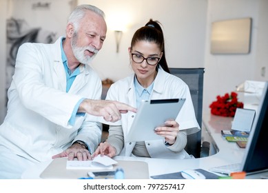 Der Arzt erklärt seinem Assistenten mithilfe des Tablettenrechners etwas. 