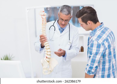 Doctor Explaining The Spine To His Patient In Medical Office