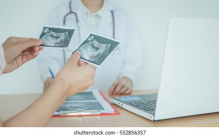 Doctor Explaining Ultrasound Scan To Pregnant Woman In Hospital.