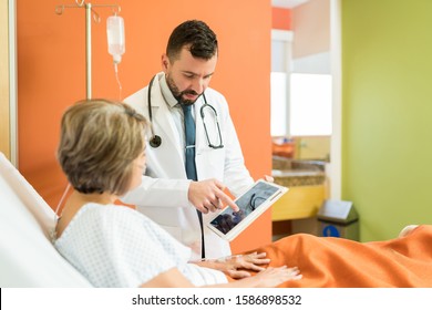 Doctor Explaining Xray On Digital Tablet To Senior Patient At Hospital