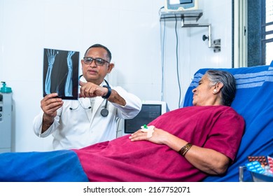 Doctor Explaining From X-ray Report To Senior Patient At Hospital Before Surgery - Concept Of Medical, Healthcare Treatment And Friendly Surgeon.