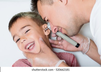 Doctor Explores The Ear To Smiling Child