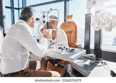 Doctor, eye exam or mature woman consulting for eyesight at optometrist or ophthalmologist. Senior customer testing vision with optician helping or checking iris or retina visual health in office - Powered by Shutterstock