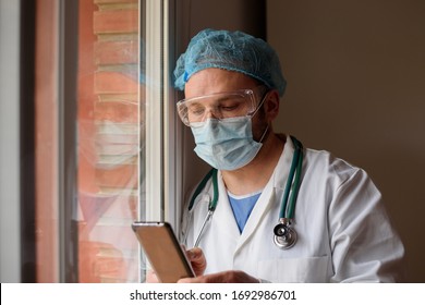 Doctor In Face Mask Using Smartphone In The Hospital