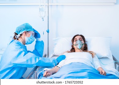 Doctor Or Family Member Holding The Hand Of A Woman Laying In Bed With Respiratory Tube In The Medical Intensive Care Unit Of A Hospital With Sterile Protection Equipment