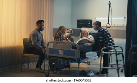 Doctor and family visiting elderly man in clinic