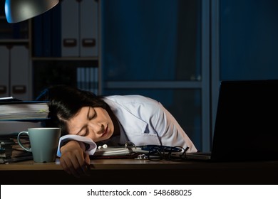 doctor feel tired sleeping on desk of clinic. beautiful mixed race asian chinese woman. medical and health concept - Powered by Shutterstock