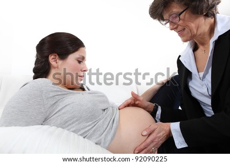 Doctor feeling a woman's pregnant stomach