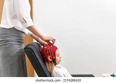 Doctor Fixing Electrodes To A Headgear Of A Patient In A Biofeedback Session