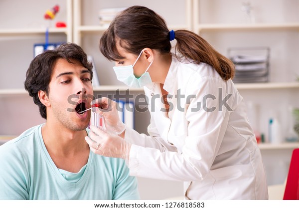 Doctor\
getting saliva test sample in clinic\
hospital